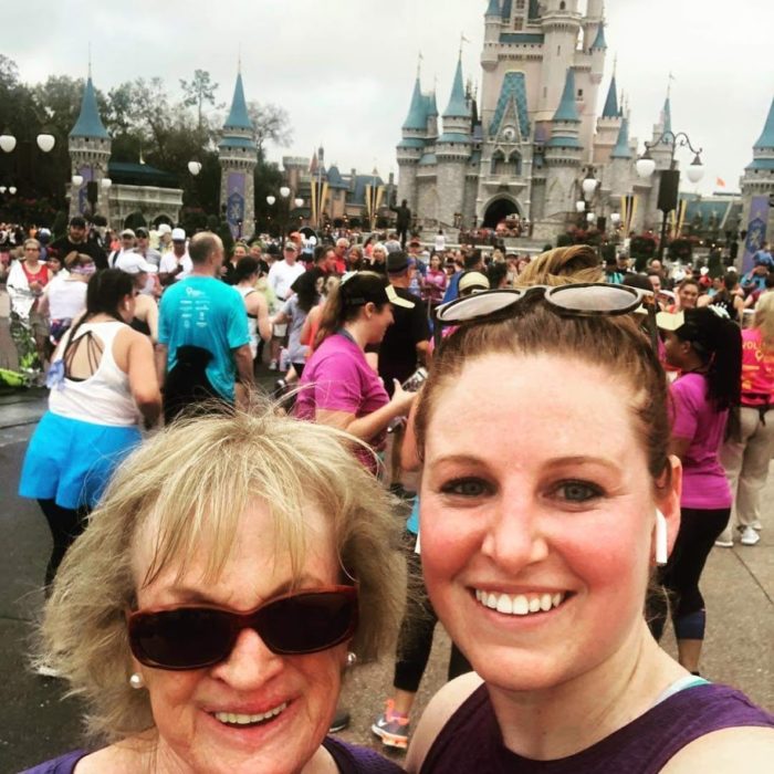 Suzanne and Caitlin stand in front of the castle at Disney.