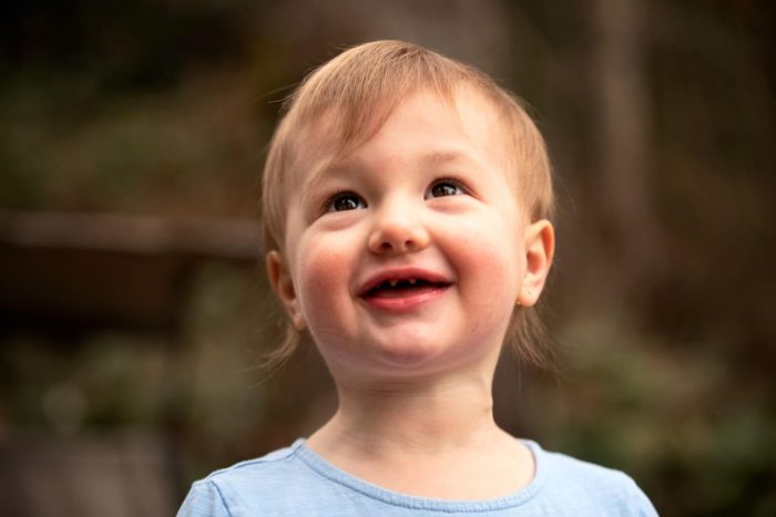 Clara is smiling and looking up.