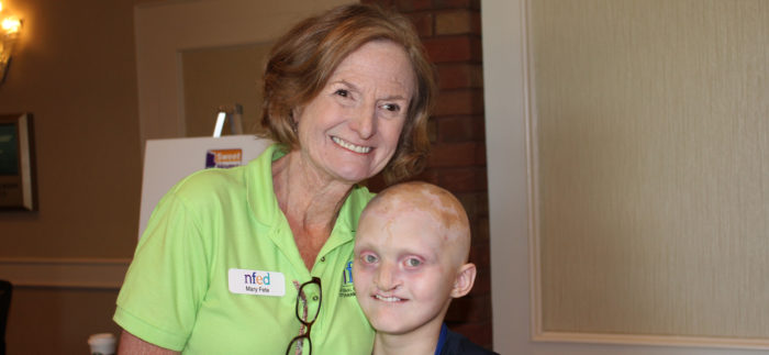 Mary Fete stands next to a boy affected by EEC syndrome. Both are smiling.