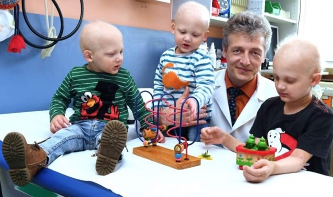 A doctor is shown with three boys affected by x-linked hypohidrotic ectodermal dysplasia. The boys are playing with toys.