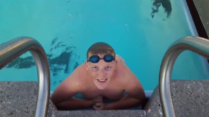 Auggie Olive smiling in the pool