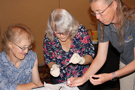 A doctor is placing a skin biopsy in a test tube held by a researcher. The woman affected by EEC syndrome who provided the biopsy watches.