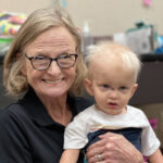 Mary Fete holding Bennett, a young boy with XLHED