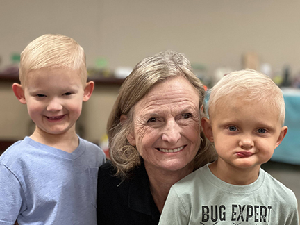 The NFED director, Mary Fete, poses with two young boys who are affected by x-linked hypohidrotic ectodermal dysplasia. The boys have sparse, blonde hair.
