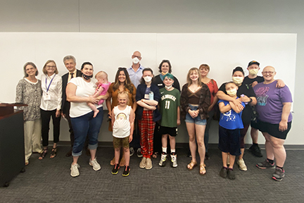 Parents and children posed for a shot with Dr. Siegfried and NFED's Mary Fete in a conference room.