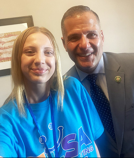Nicole is wearing her blue ELSA t-shirt with Rep. Molinaro who is wearing a grey suit and blue tie.