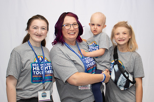 Two women, a boy and a girl all wear matching conference shirts. The little boy has no hair. Each are affected by a syndrome caused by the TP63 gene.